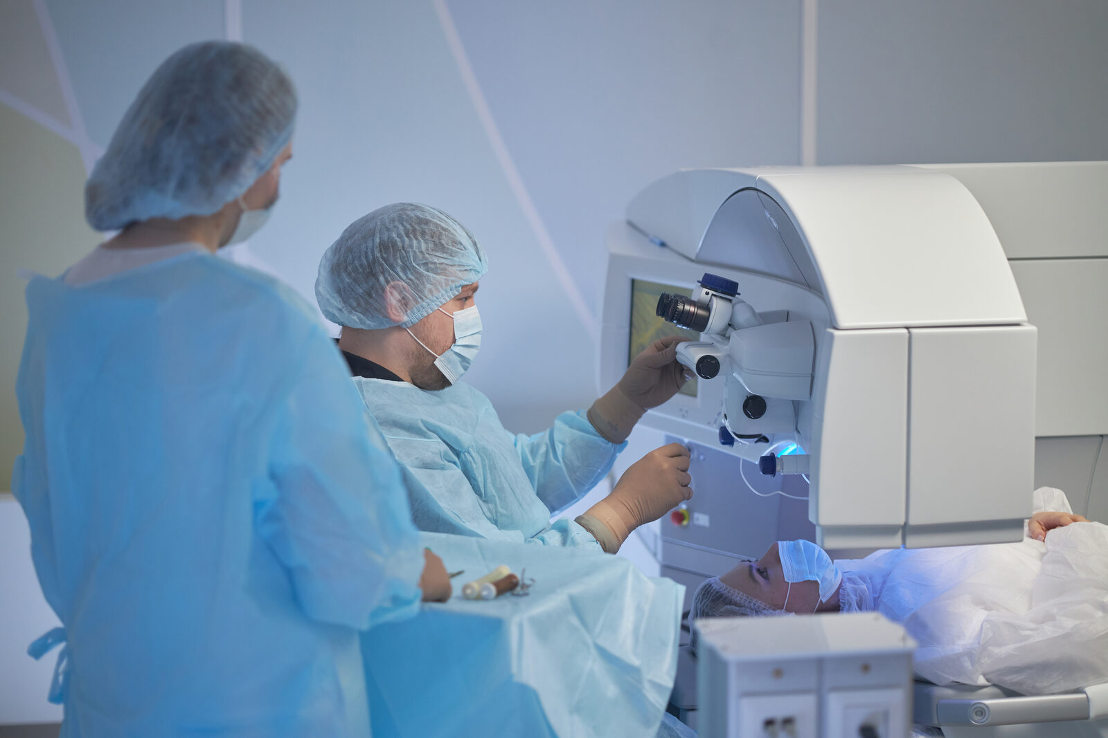 Surgical team performing a refractive eye procedure in an operating room