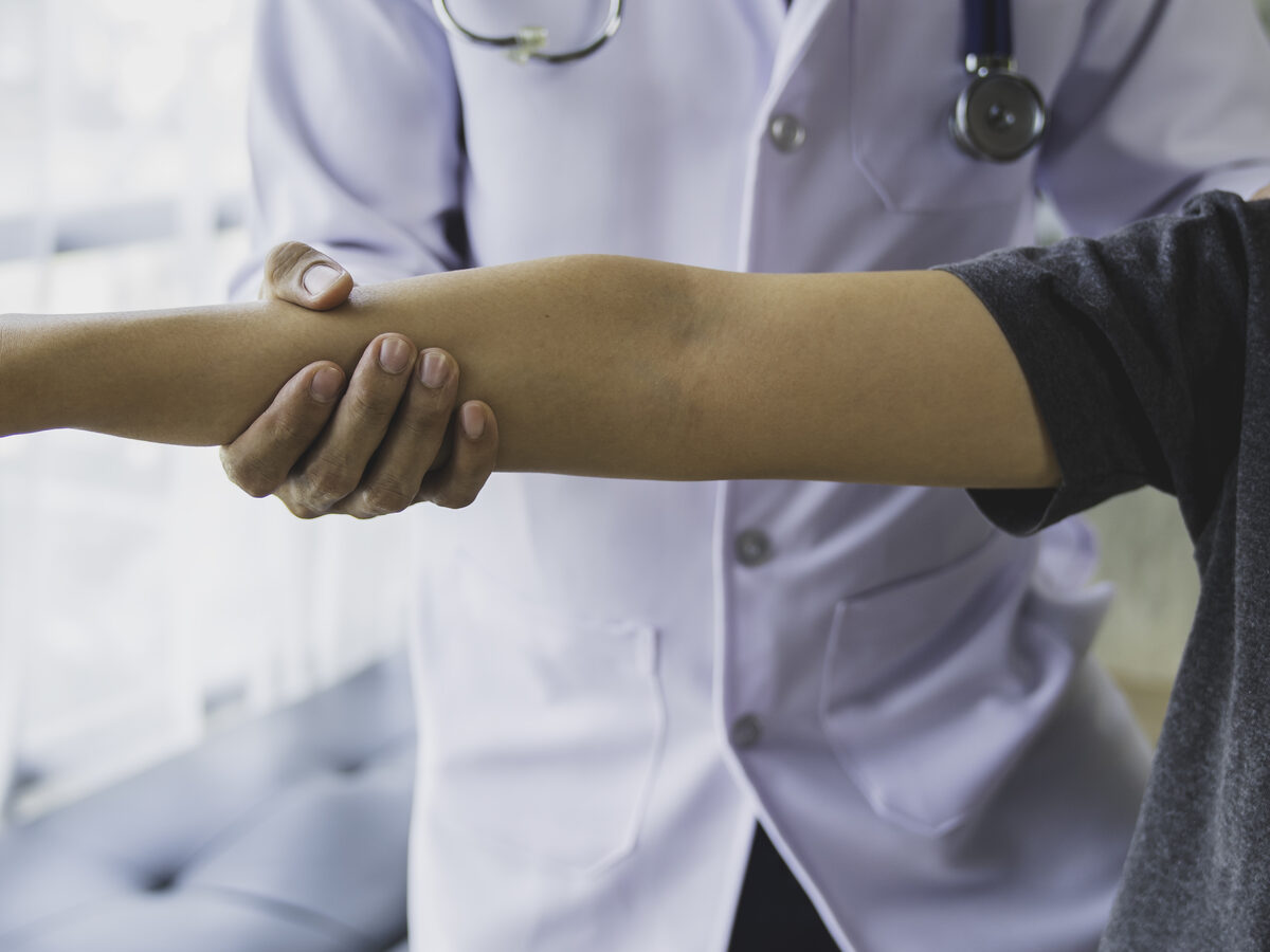 Doctor examining a patient's arm during a physical exam