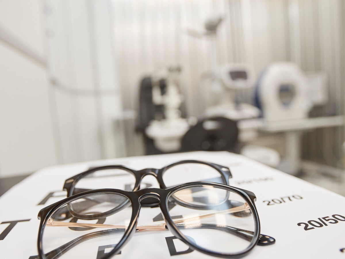 Eyeglasses resting on a printed eye-exam chart