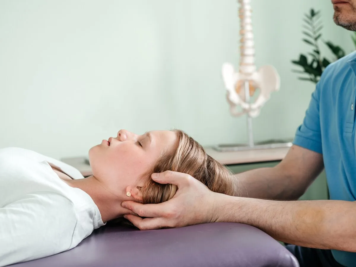 Clinician performing a musculoskeletal examination on a treatment table